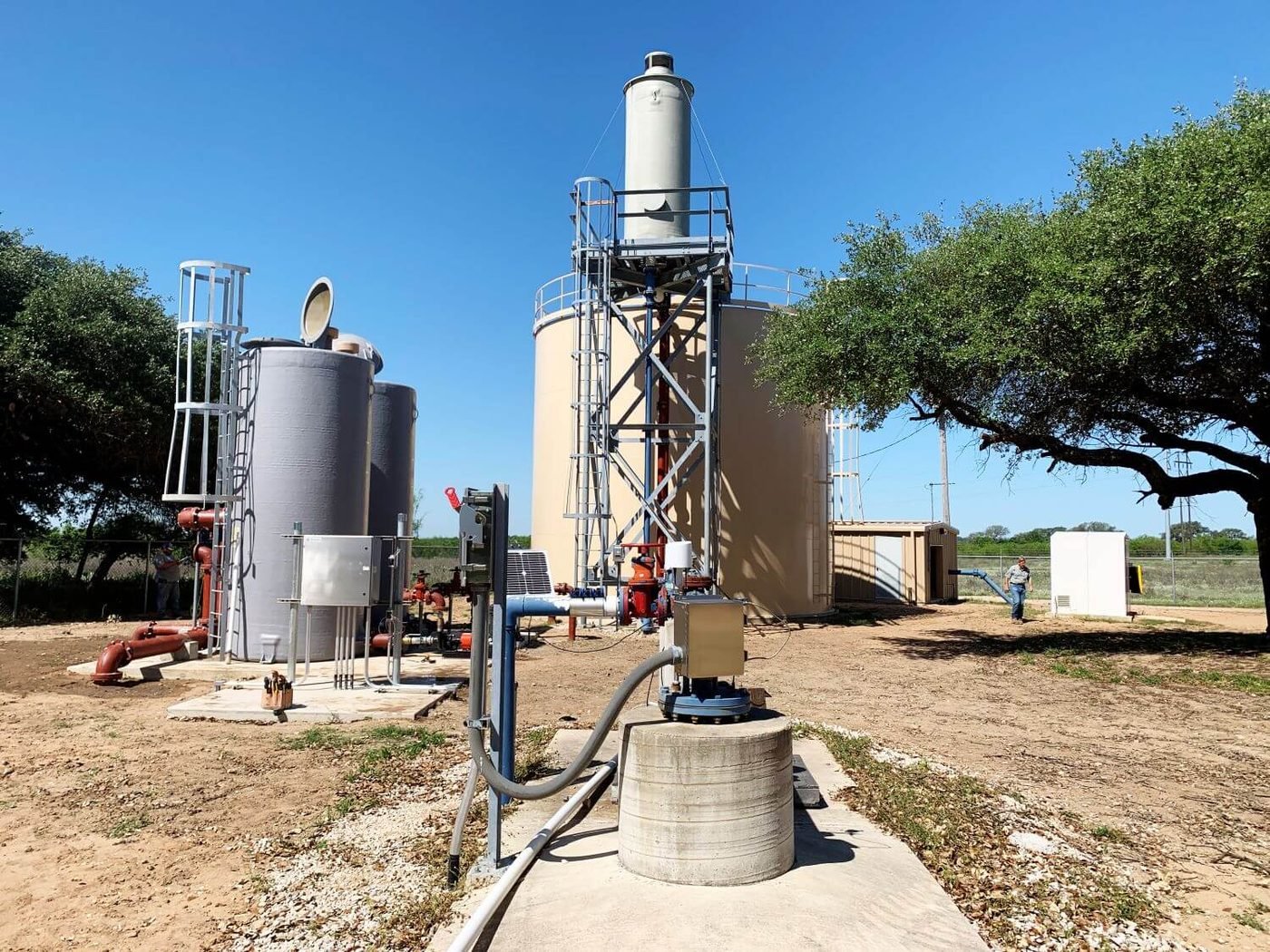 WETS elevated aerator on its steel structure beside a ground storage tank, with pressure filters and well head