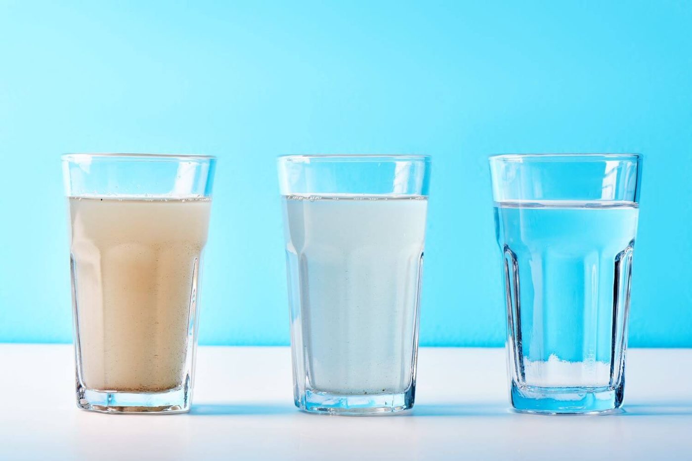 Three glasses of water ranging from turbid and discolored to clear